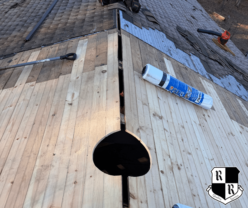 On a red shingled roof, a white vent boot is installed with a hammer, pry bar, and pliers nearby; worker's shoes visible at bottom.