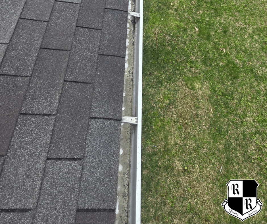 On a red shingled roof, a white vent boot is installed with a hammer, pry bar, and pliers nearby; worker's shoes visible at bottom.